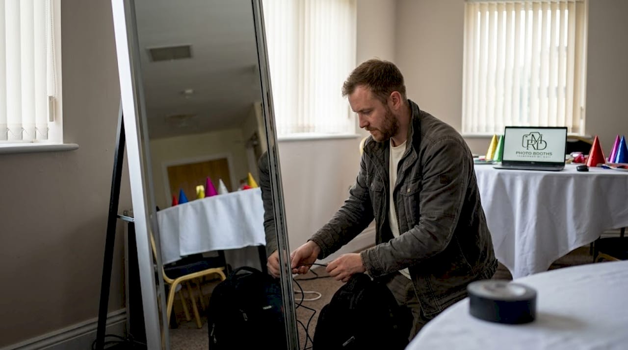 Technician assembling mirror photo booth at event