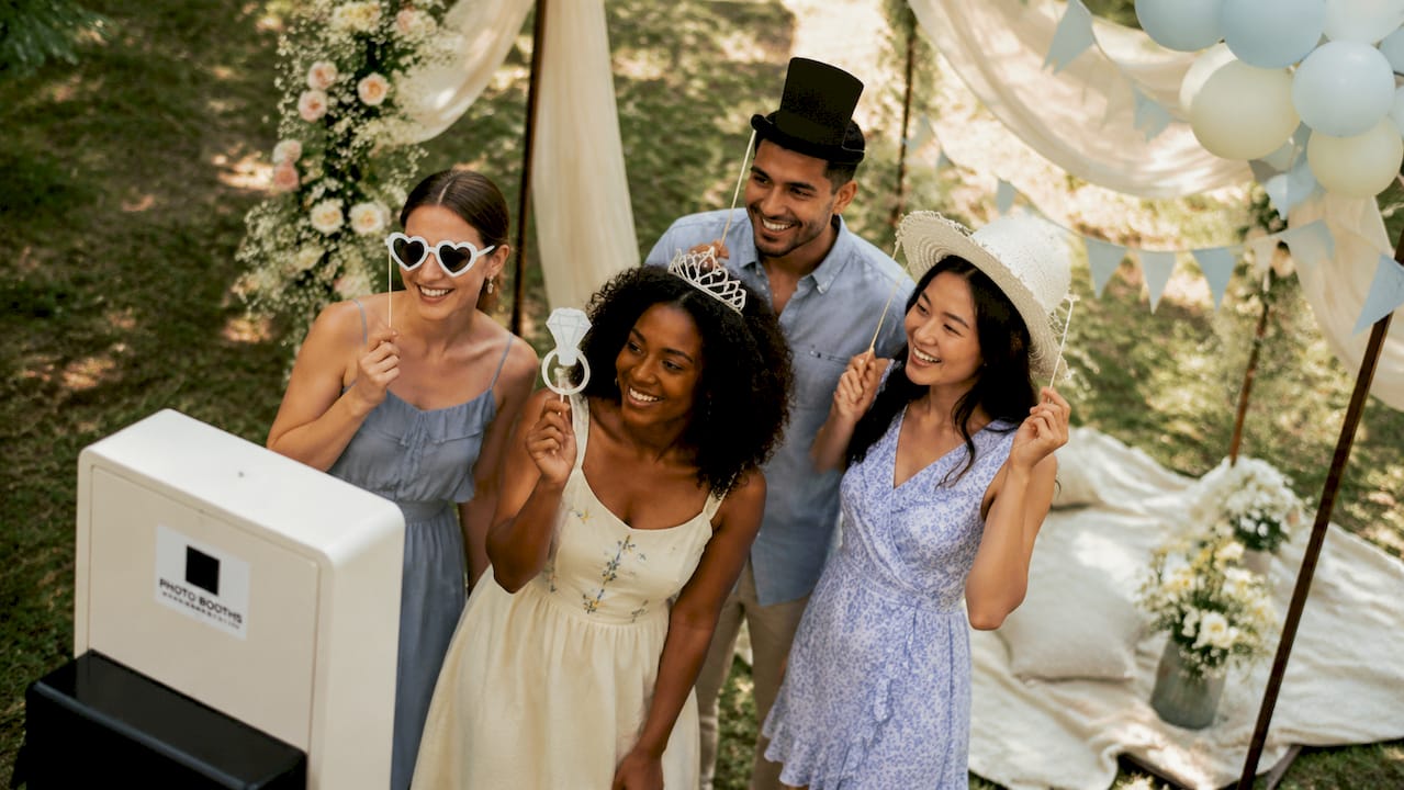 Guests using classic event photo booth props outdoors
