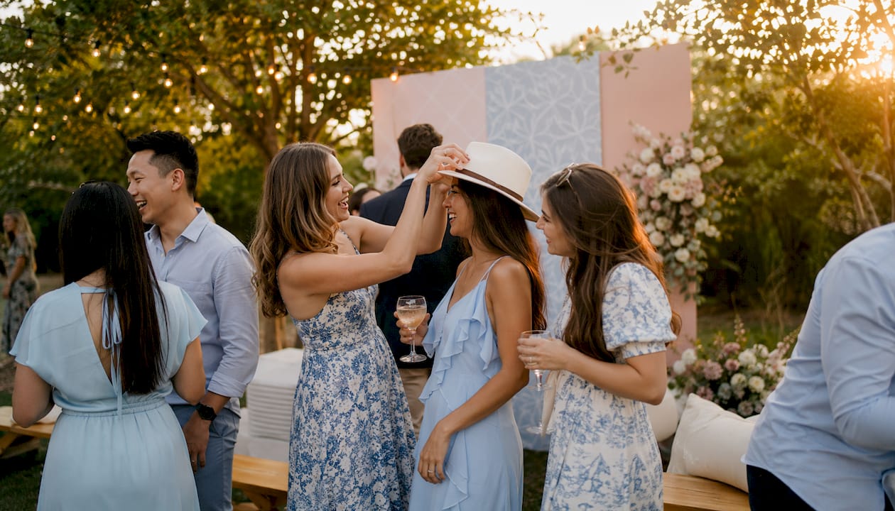 Guests enjoying party with event backdrop