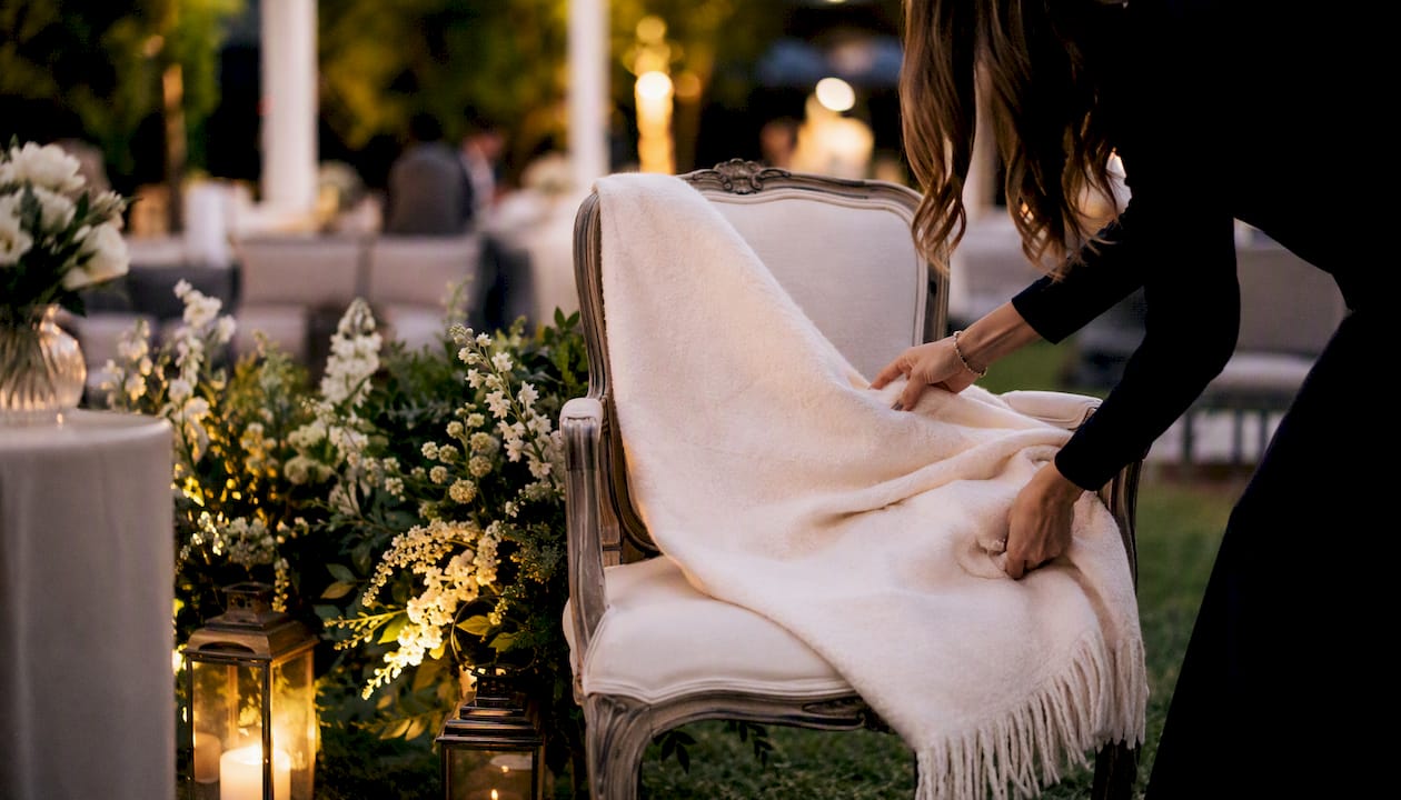 Hands arranging cushion on designer event chair